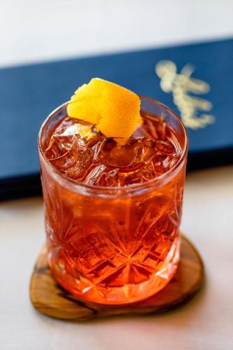 a drink sitting on a wooden coaster with a drink at Hotel Lulu in Round Top