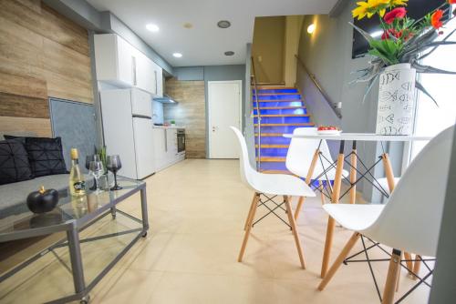 a living room with a table and chairs and a staircase at bella Kerkyra in Agios Rokkos
