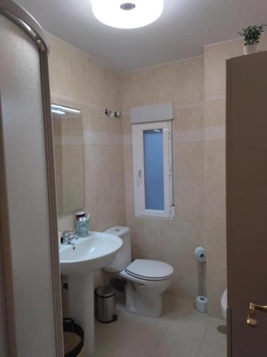 a bathroom with a white toilet and a sink at Castillo Triste Condesa in Arenas de San Pedro