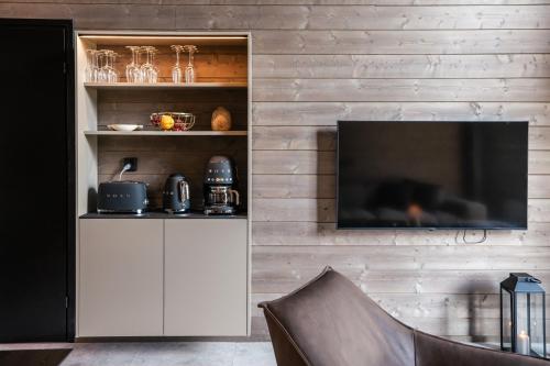 a living room with a television on a wall at Luxurious Rakka Suites, Ylläs in Äkäslompolo