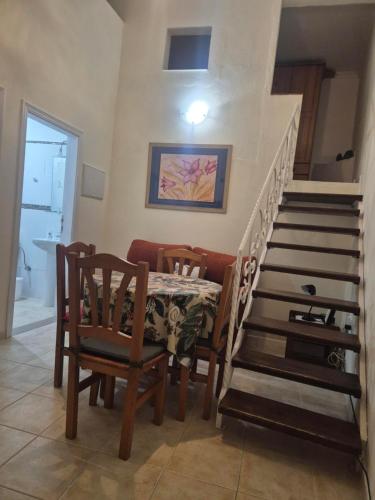 a dining room with a table and chairs and stairs at Casa Cira in Calera