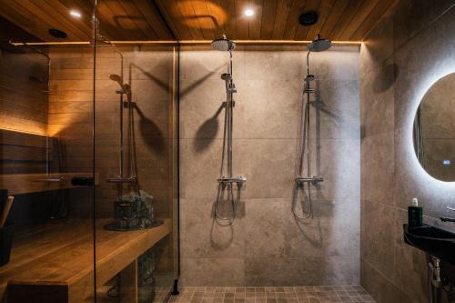 a bathroom with a shower with a glass door at Luxurious Rakka Suites, Ylläs in Äkäslompolo