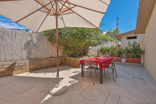 a table and chairs with an umbrella on a patio at Camping Europa in Capoliveri
