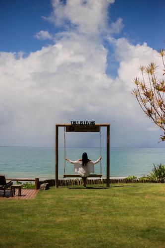 a woman is on a swing at the beach at Beijo do Vento Pousada in Arraial d'Ajuda