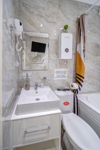 a white bathroom with a sink and a toilet at Spa King Apartments 3 in Belgrade