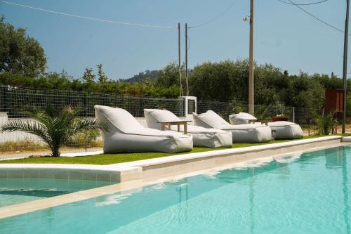 a swimming pool with white inflatable chairs and a swimming pool at Ethéreal Thassos in Limenas