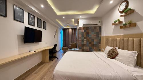 a bedroom with a bed and a desk and a tv at The luxurious cozy stay in Jaipur