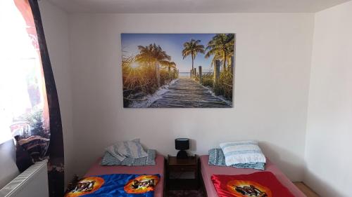 two beds in a room with a picture on the wall at Ubytování Stráž 2 in Stráž