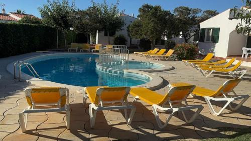 a group of chairs and a swimming pool at Binibasket in Ciutadella