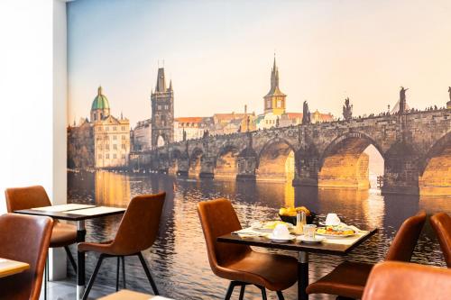 a restaurant with a view of a river and a bridge at Hotel Oáza Praha in Prague