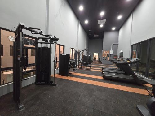 a gym with several treadmills and cardio machines at Vetro11 Beside QEH1 by JUNE Homestay in Kota Kinabalu
