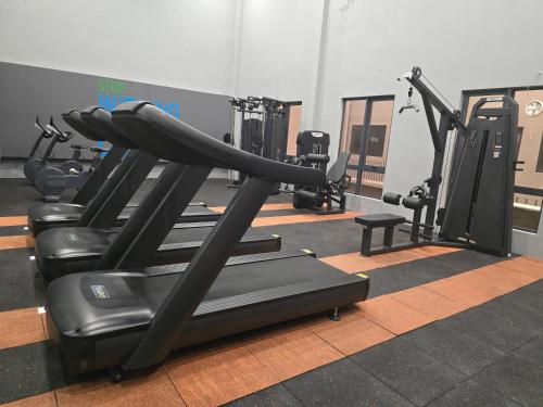 a gym with rows of tread machines in a room at Vetro11 Beside QEH1 by JUNE Homestay in Kota Kinabalu