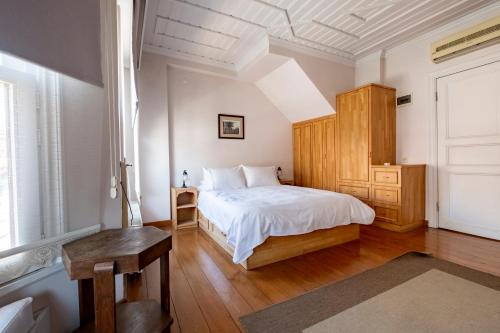 a bedroom with a white bed and a wooden cabinet at House with Terrace in Sultanahmet in Istanbul