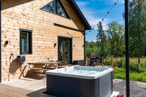 a hot tub on a deck next to a building at Himos Stonelake - two saunas and a hot tub in Jämsä