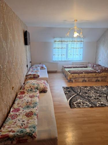 a room with three beds and a tv and a window at Penzion Anna in Hrabušice