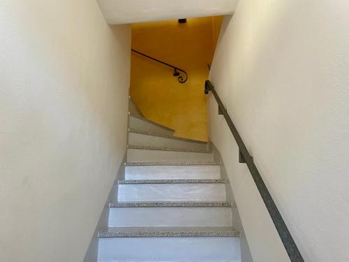 a staircase in a building with white walls and white stairs at Il Girasole in Mandello del Lario