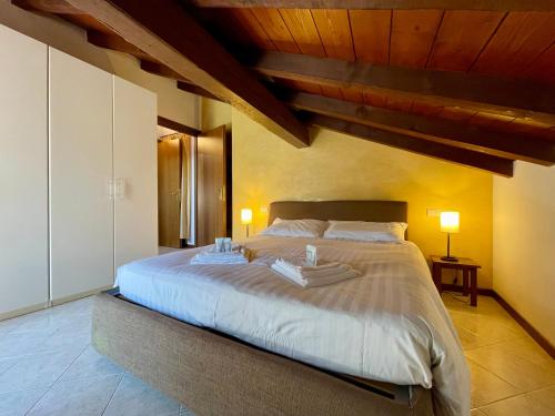 a bedroom with a large bed with two towels on it at Il Girasole in Mandello del Lario