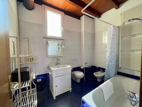 a bathroom with a tub and a toilet and a sink at Il Girasole in Mandello del Lario