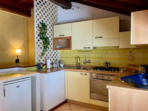 a kitchen with white cabinets and a stove at Il Girasole in Mandello del Lario