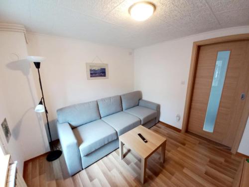 a living room with a blue couch and a table at Apartma Nando in Bovec