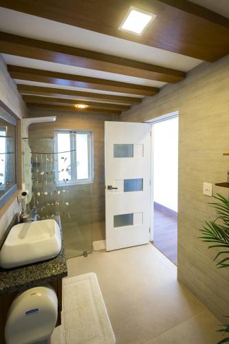 a bathroom with a sink and a shower and a door at RIBERAMAR Las Terrenas, Samana in Las Terrenas