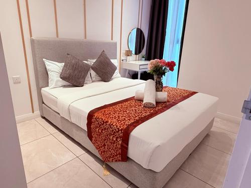 a bedroom with a bed and a vase of flowers on a table at Luxury Axon Residence Bukit Bintang KLCC PAVILION By IZ in Kuala Lumpur