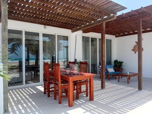 萨尔雷Villa Cristina Alojamento, Praia de Chaves, Boa Vista, Cape Verde, WI-FI的露台上的木桌和椅子