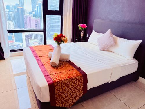 a bedroom with a bed with a vase with flowers on it at Luxury Axon Residence Bukit Bintang KLCC PAVILION By IZ in Kuala Lumpur