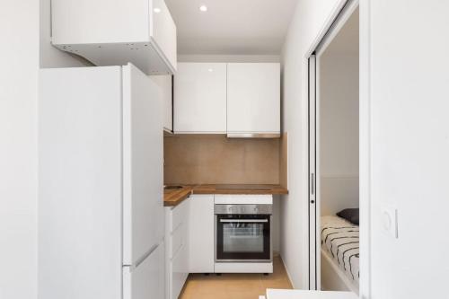 a small kitchen with white cabinets and a stove at La Gravette Coeur du vieil Antibes in Antibes