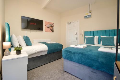a bedroom with two beds and a flat screen tv at Belgrade Lodge Studio 5 - Free Netflix, Fast WiFi, Parking in Coventry