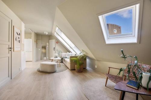 an attic living room with a skylight and a window at Top-Floor Gem with City Views in Bergen