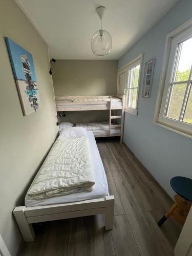 a bedroom with a bed and two bunk beds at Strandhuis De Bakkeete B in Kamperland