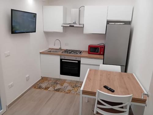 a kitchen with a wooden table and a microwave at La casa di Laura in Tortolì