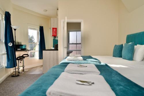 a hotel room with a bed with towels on it at Belgrade Lodge Studio 6 - City Centre, Parking, Netflix, Superfast WiFi in Coventry