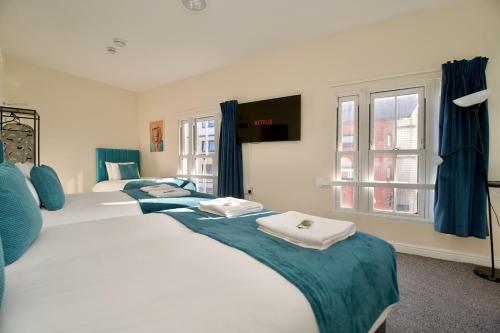 a bedroom with two beds with towels on them at Belgrade Lodge Studio 6 - City Centre, Parking, Netflix, Superfast WiFi in Coventry