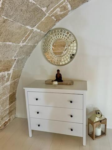 a white dresser with a mirror on top of it at Parabita Historical Home in Parabita