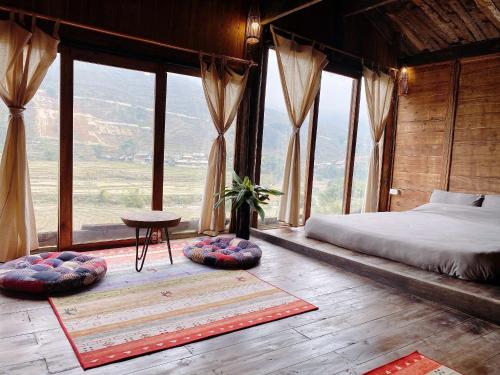 Un dormitorio con una cama y una ventana grande. en Lee Eco House Sapa, en Sa Pa