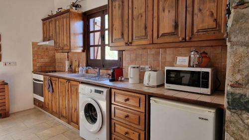 a kitchen with a washing machine and a microwave at Traditional House with Mountain View - Dierona Village in Dierona