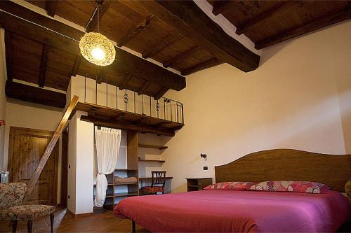 a bedroom with a red bed and a staircase at Agriturismo Prato Fiorito in Bagni di Lucca