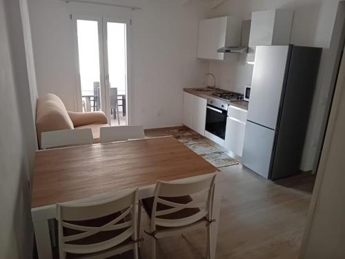 a kitchen with a wooden table and white appliances at La casa di Laura in Tortolì