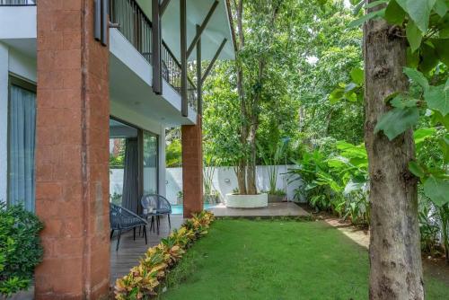 a patio with a lawn in front of a house at Casa Aurem - Luxury 4bhk villa with pool in Goa