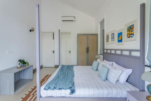 a bedroom with a bed with blue and white pillows at Casa Aurem - Luxury 4bhk villa with pool in Goa