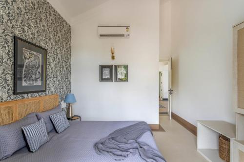 a bedroom with a bed with a blanket on it at Casa Aurem - Luxury 4bhk villa with pool in Goa