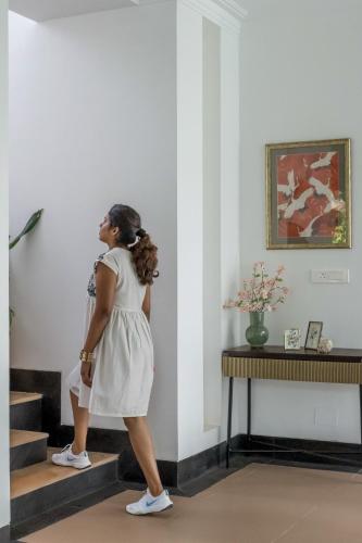 a woman in a white dress walking up some stairs at Casa Aurem - Luxury 4bhk villa with pool in Goa