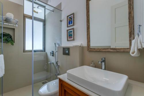 a bathroom with a sink and a toilet and a shower at Casa Aurem - Luxury 4bhk villa with pool in Goa