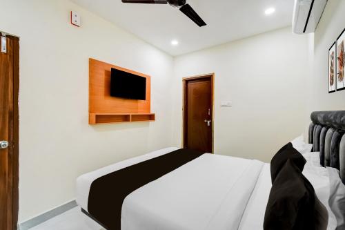 a bedroom with a bed and a tv on the wall at Super Townhouse Oak LB Metro Station Formerly Sunil Arcade in Surūrnagar