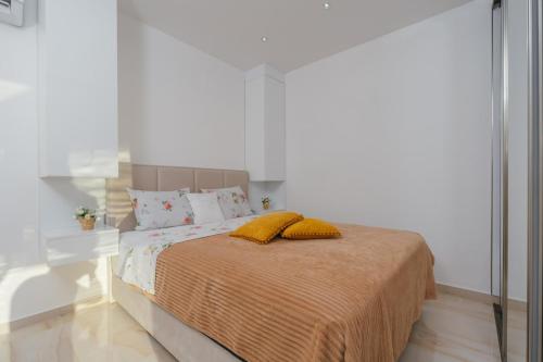 Dormitorio blanco con cama con almohadas amarillas en Altura Panorama, en Bar
