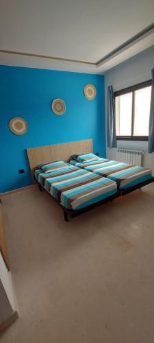Un dormitorio con dos camas en una pared azul en Ahlem, en Tabarka