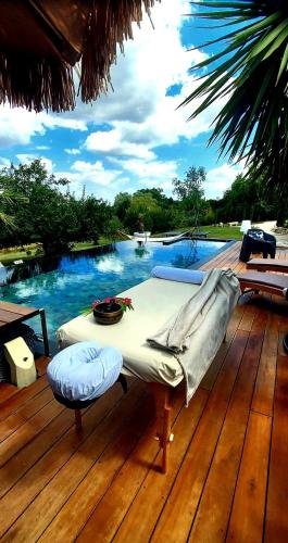 a table on a deck next to a swimming pool at La chambre l'Eucalyptus in Saint-Laurent-du-Bois