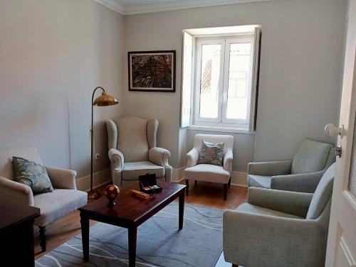 a living room with chairs and a table and a window at Mourisca 1810 Guest House in Águeda